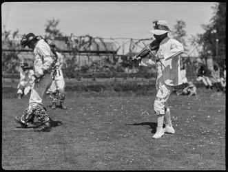 Un membre de la troupe de Bampton Morris se produisant dans une "Pipe Dance", accompagné par le joueur de violon.