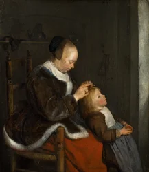Mère épouillant les cheveux de son enfant