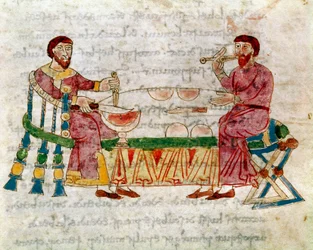 Deux hommes à table pendant un repas tiré du volume « De Mensis et Escis », manuscrit « De Universo » (ou De rerum naturis (De la Nature des choses)) (cod. 132) par Rabanus Maurus Magnentius (ou Raban Maur ou Rabano Mauro) (ca. 780-856). 9ème siècle. Archi