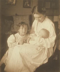 [Mère en robe de chambre, assise, avec un nourrisson et un petit garçon].