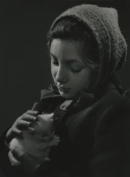Fille tenant un chaton blanc dans ses bras. Début des années 1950