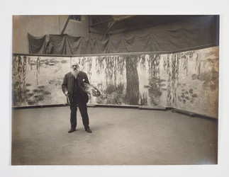 Claude Monet avec sa palette devant son œuvre 
