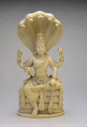 Vishnu, assis sur le serpent Sesha, tenant une coquille, une masse, un disque et un lotus