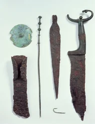 De haut en bas : couteau, fer de lance, hameçon, épingle à linge, disque de ceinture et hache, tous trouvés dans des tombes masculines à Hallstatt, âge du fer