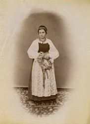Jeune femme portant une robe de mariée et tenant un anneau de pain enveloppé de ruban, Parre, Lombardie, Italie