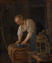 Femme récurant des ustensiles en métal