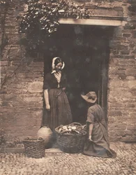 [Deux femmes, une agenouillée et une debout, regardant dans un panier rempli de légumes]