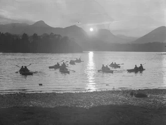 Vue de personnes faisant du canoë sur Derwentwater au lever ou au coucher du soleil.