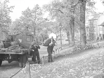 Camion dans la rue avec deux charbonniers transportant des sacs de charbon