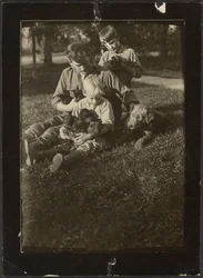 [Homme avec enfants et chiots dans la cour]