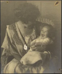 [Une mère en robe brodée et son nourrisson]