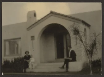 [Femme et homme devant une maison]