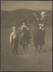 [Femme et trois enfants dans un champ]
