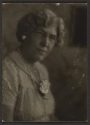 [Femme avec une fleur blanche et des perles]