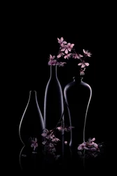 Fleurs roses dans des vases sombres