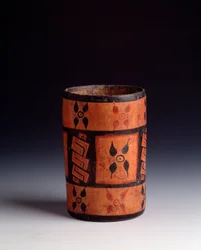 Vase cylindrique en argile polychrome avec des fleurs. De Tikal