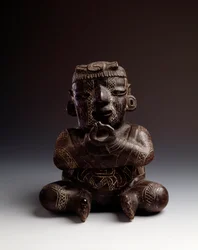 Art précolombien, civilisation maya, période initiale : vase anthropomorphe en argile représentant un homme assis, les mains jointes en forme de cercle. Provenant d