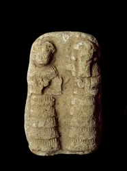 Civilisation sumérienne : couple de dieux sur le trône. Sculpture en terre cuite. Dimensions : 9 cm. Période néo-sumérienne (entre 2093 et 2004 av. J.-C.). Bagdad, Musée national d