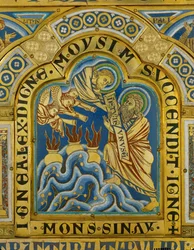 Dieu donne à Moïse les dix commandements, tandis que des anges sonnent de la trompette.