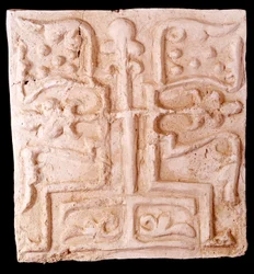 Art paléochrétien : pierre ornée de reliefs de branches de vigne et d