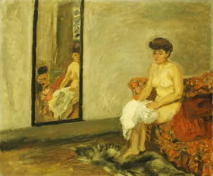 Nu assis sur une chaise rouge