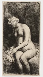 Femme nue assise, les pieds dans l