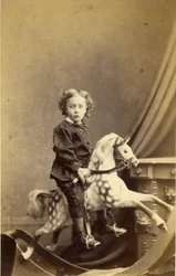 Jeune garçon assis sur un cheval à bascule, années 1860