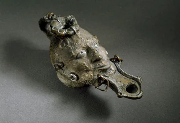 Art romain : lampe à huile en bronze en forme de visage