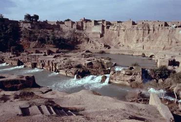 Vestiges du complexe pont-barrage-canal de Sika sur la rivière Gar-Gar avec la ville de Shushtar en arrière-plan