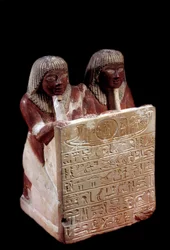 Antiquité égyptienne : statue en calcaire servant de stèle au nom de Didi et de son fils Padoua. Nouvel Empire. Deir el-Médineh. Paris, Musée du Louvre
