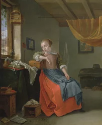 Une femme assise dans un intérieur regardant par la fenêtre