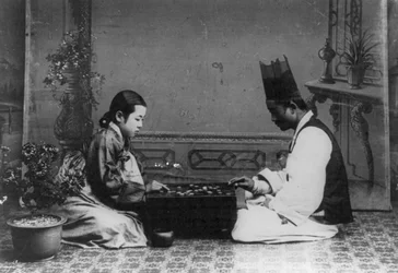 Un homme et une femme jouant au baduk ou au "go", vers 1910