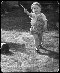 Andrew Nurnberg, fils du photographe Walter avec un bâton dans le jardin, vers 1954