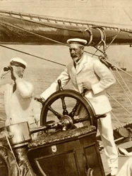 Le roi George V à la barre de son yacht, Britannia, pendant la semaine de régates de Cowes