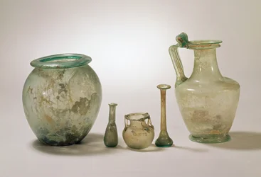 Collection de verre romain : urne cinéraire, verrerie funéraire et cruche, Ier-IVe siècle