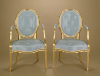 Paire de fauteuils dorés à dossier ovale de style Adam, tapissés de bleu, c.1780