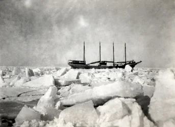 Un navire à quatre mâts naviguant parmi les icebergs