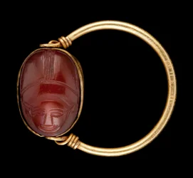 Scarabe en cornaline avec visage humain serti dans une bague en or