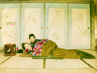 Allongées sur un futon. Deux femmes japonaises allongées sur un futon traditionnel placé sur le sol. Japon, vers 1910.