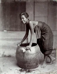 Jeune femme thaïlandaise souriante, poussant un grand conteneur