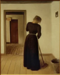 Intérieur avec une jeune femme balayant