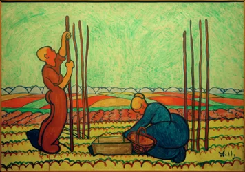 Homme et femme plantant des tuteurs de haricots