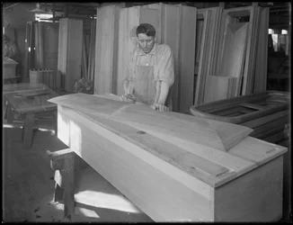 Ouvrier ajustant une pièce de couvercle de cercueil, Oneida, New York, 3 avril 1916