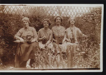 Quatre femmes avec des appareils photo Kodak, y compris des appareils Brownie, vers les années 1900